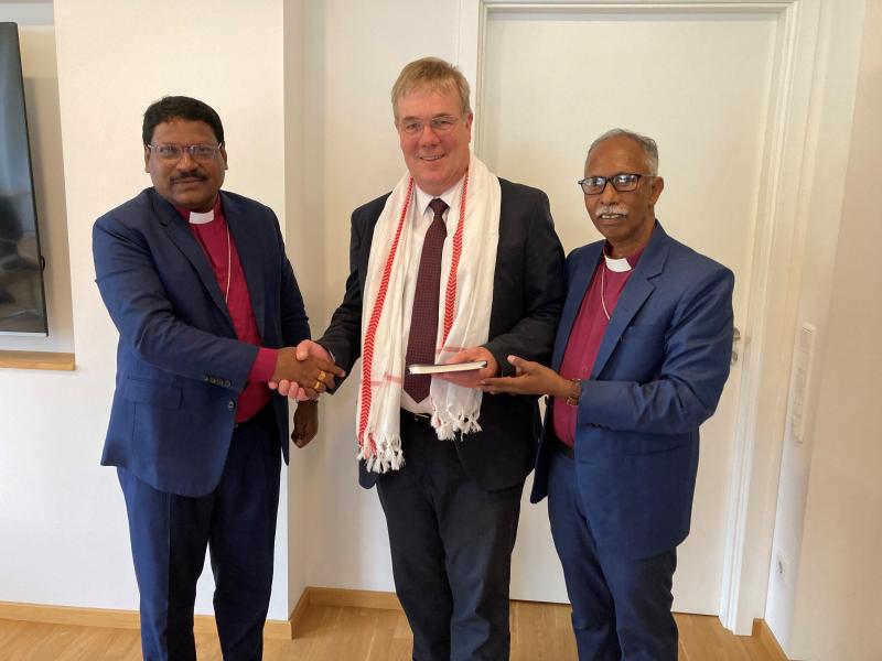 Indische Gäste in Lippe - Die indischen Bischöfe Marshel Kerketta (li.) und Muarel Bilung (re.) überreichen Landessuperintendent Arends (mi.) als Gastgeschenk einen traditionellen Schal.